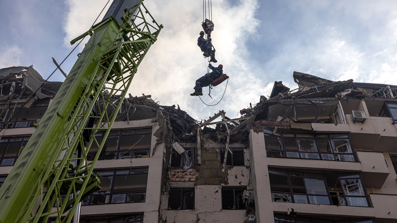 Rescatistas laboran en un edificio residencial dañado por los ataques aéreos rusos en el distrito de Shevchenkivskiy en Kiev, Ucrania