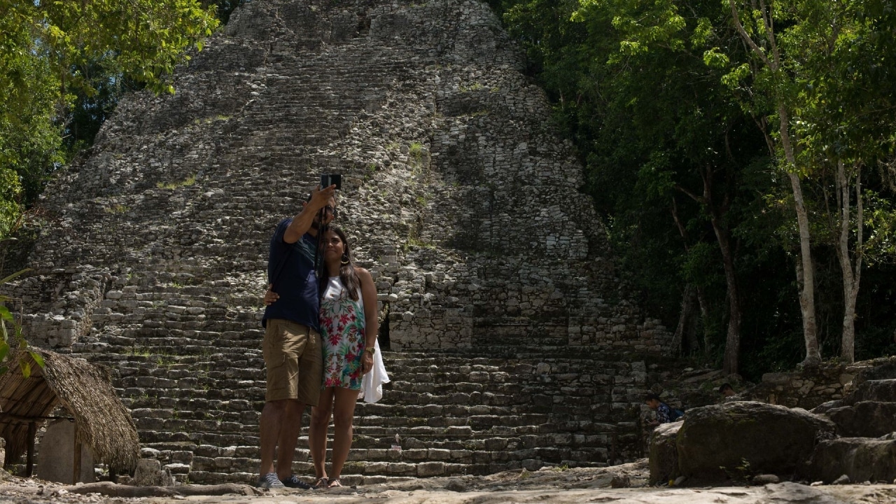 Fotografía que muestra a una pareja de turistas en las ruinas arqueológicas de Cobá, que tienen una extensión de 70 km.