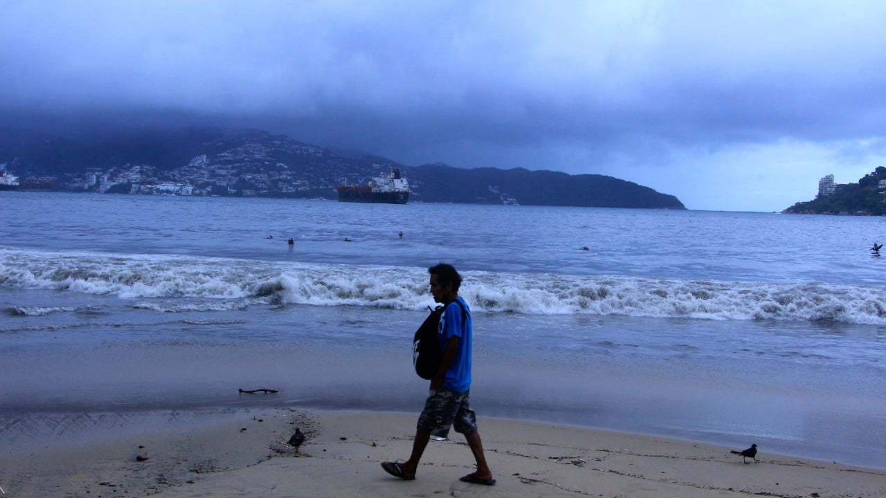 Una persona camina sobre una playa de Acapulco.