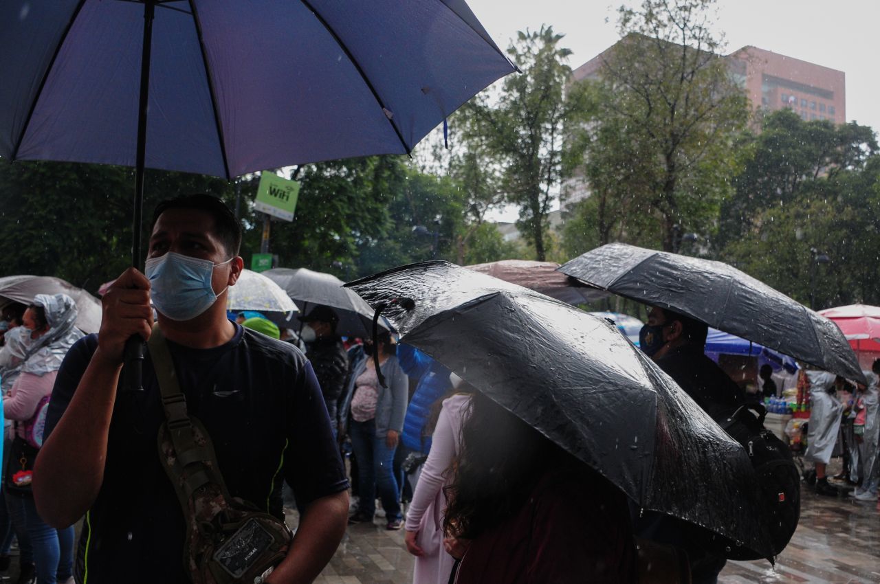 Los capitalinos caminan por las calles del Centro Histórico mientras se protegen de la lluvia (Cuartoscuro)