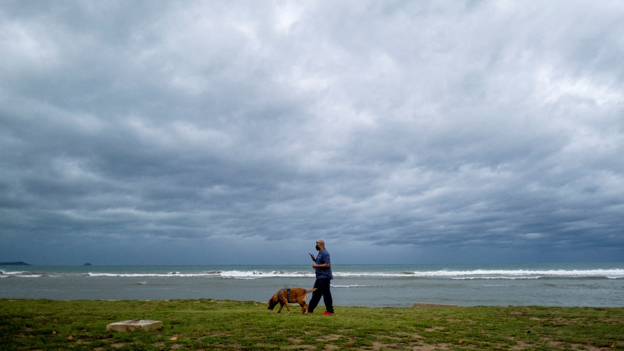 Un hombre pasea a su perro mientras se acerca el huracán Fiona a Ponce, Puerto Rico.