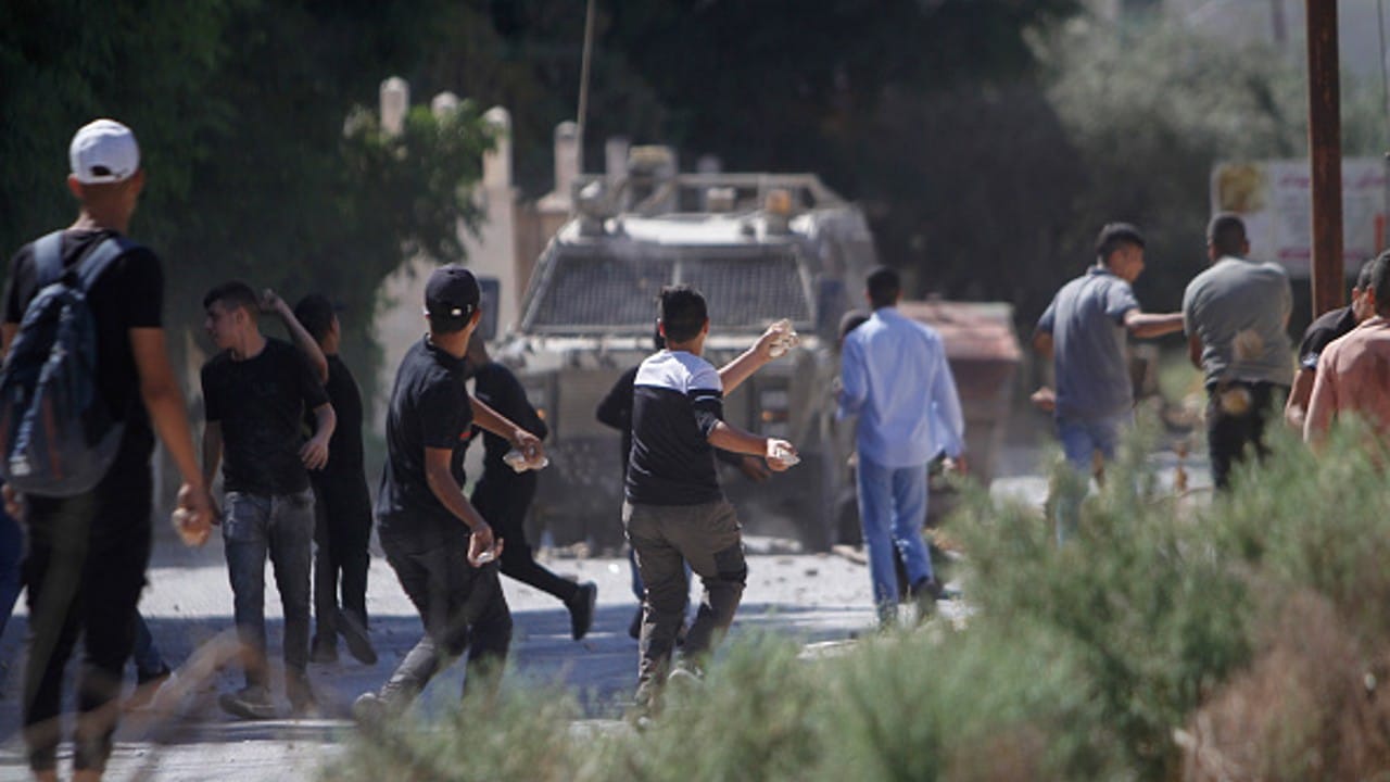 Palestinos arrojan piedras a vehículo militar israelí