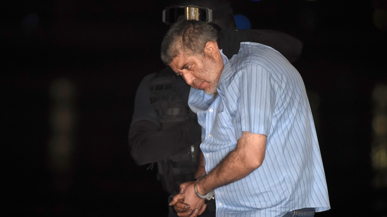 Fotografía del narcotraficante Vicente Carrillo Fuentes, mientras es escoltado por un oficial de policía tras su detención, el 9 de octubre de 2014.