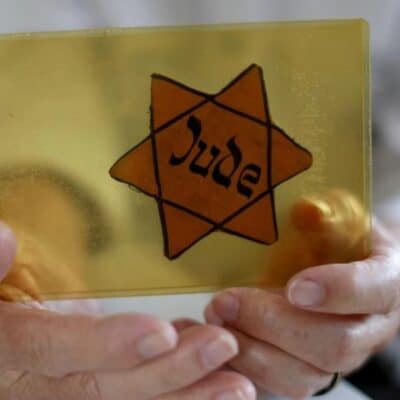 Sobreviviente del Holocausto muestra la insignia que los nazis los obligaban a usar. Foto: AFP