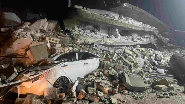 Un automóvil debajo de los escombros de un edificio derrumbado en Azmarin, Turquía. Foto: AP